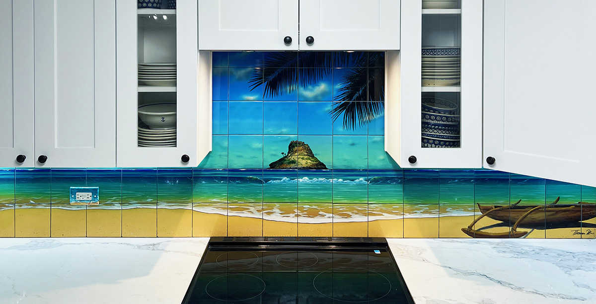 A Kitchen tile mural backsplash featuring a view of Chinaman's Hat and a canoe from a beach on Oahu's windward coast.